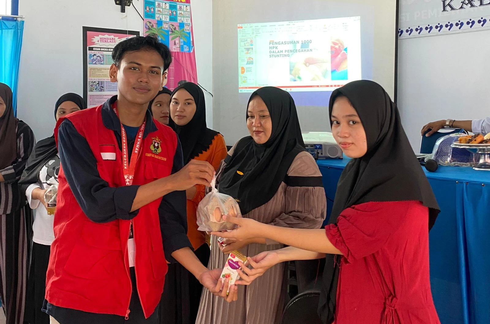 
Mahasiswa KKN 114 Kabupaten Wajo menyerahkan makanan bergizi berupa telur dan susu kepada salah satu peserta sosialisasi pencegahan stunting di Kelurahan Sompe, Rabu (23/7/2025). Pembagian ini merupakan bagian dari upaya pemenuhan gizi untuk ibu hamil. Kredit: Dokumentasi KKN 114 Unhas.